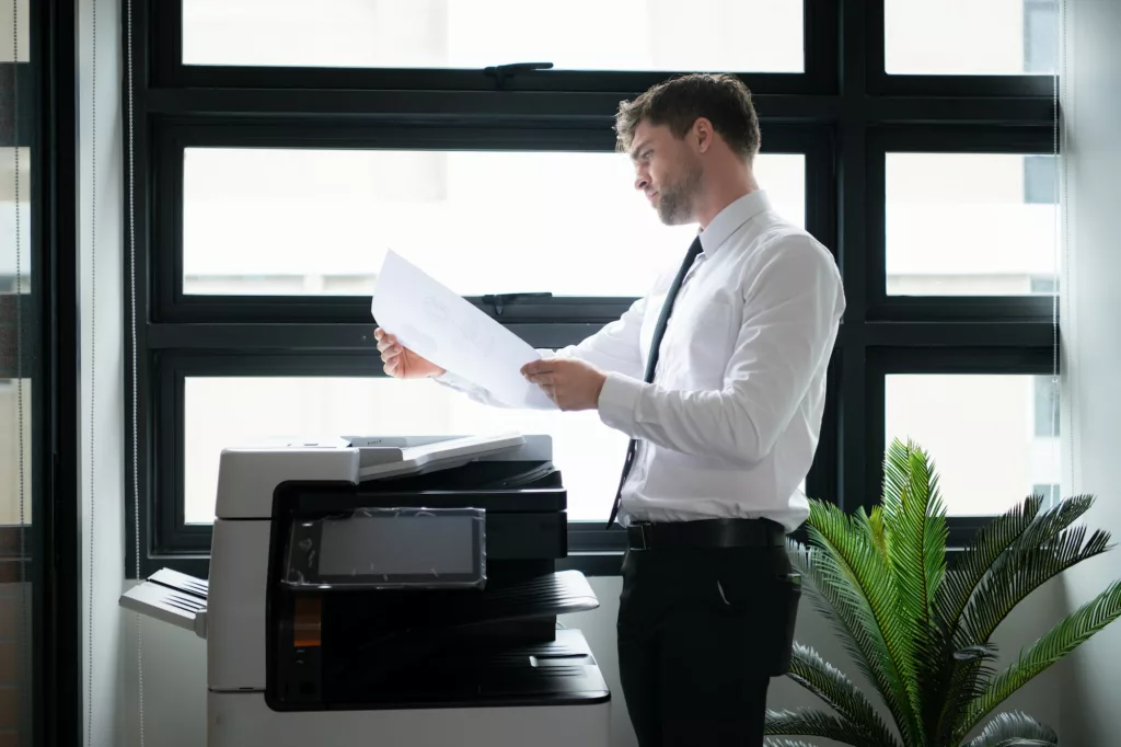 Businessman in office working with copier. Image for office equipment/copiers/printers pages of the document solutions section of the mcc website